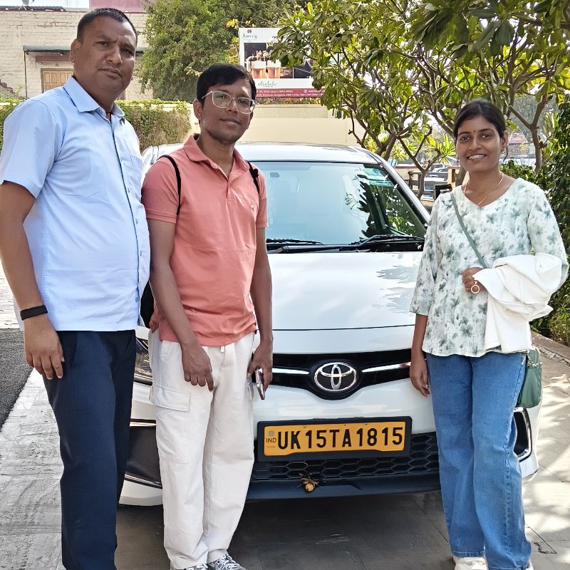 Travellers together beside their taxi